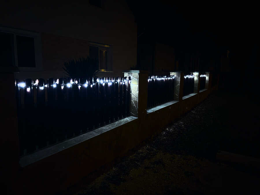 Karácsonyi fényfüzér a kerítésen